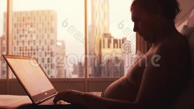 在<strong>日</strong>落时分，<strong>肥胖</strong>的新郎躺在床上，在城市建筑的大窗户旁的笔记本上玩游戏
